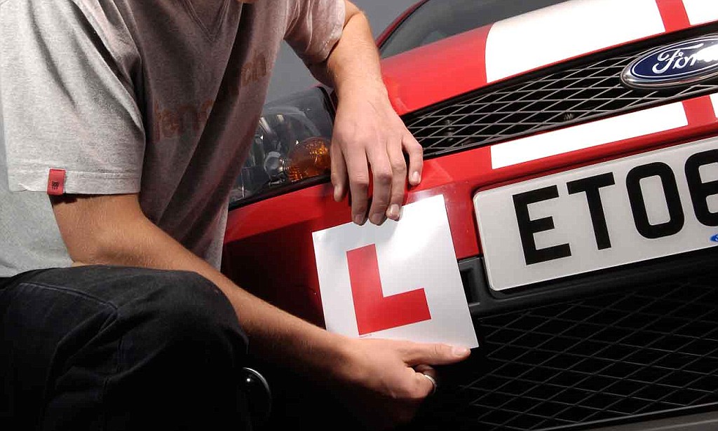 driver putting L plates on car