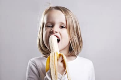 девочка ест банан