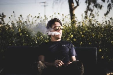парень курит на скамейке
